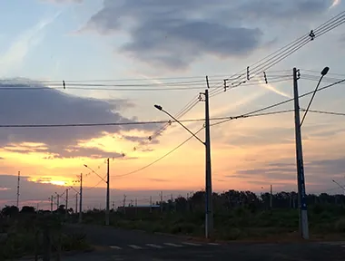 Rede de distribuição de energia elétrica em loteamento ao entardecer